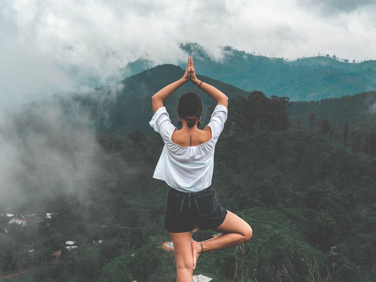 A person practising yoga on a mountain ridge
